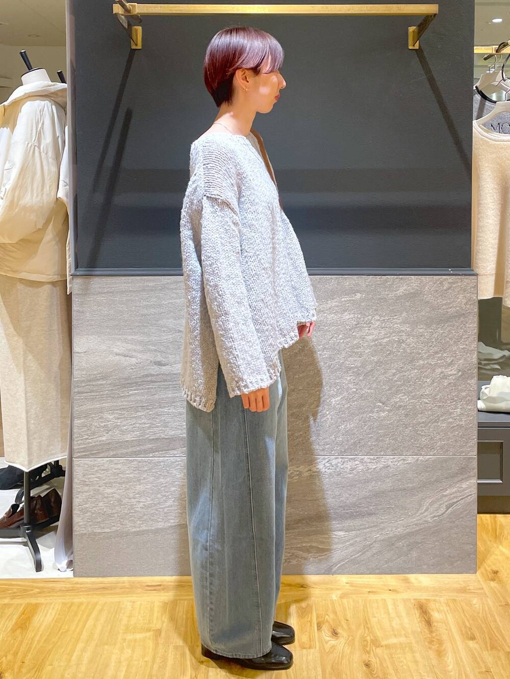 ブルー系のデニムパンツ、ブラック系のローファー、グレー系のニット/セーターを着用したレディースの秋コーディネートの3枚目の写真