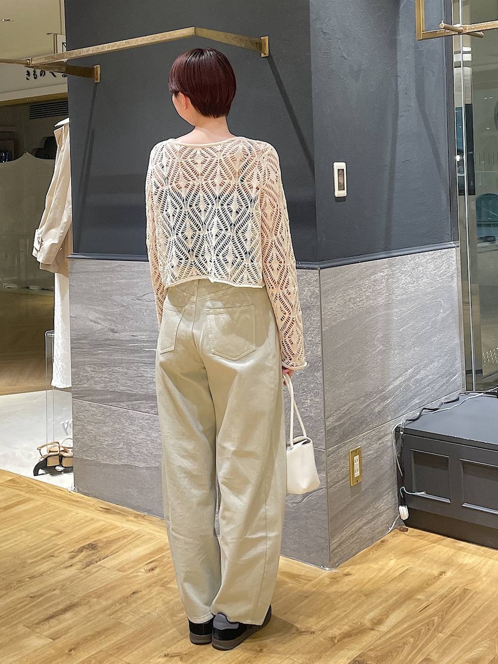 ベージュ系のデニムパンツ、ホワイト系のショルダーバッグ、ホワイト系のカーディガン/ボレロを着用したレディースの春コーディネートの4枚目の写真