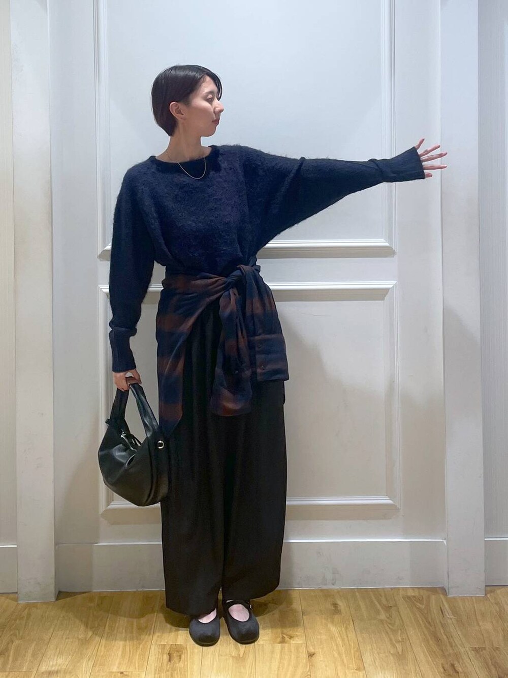 ブラック系のハンドバッグ、ブラック系のスラックス、ブラック系のバレエシューズを着用したレディースの秋コーディネートの2枚目の写真