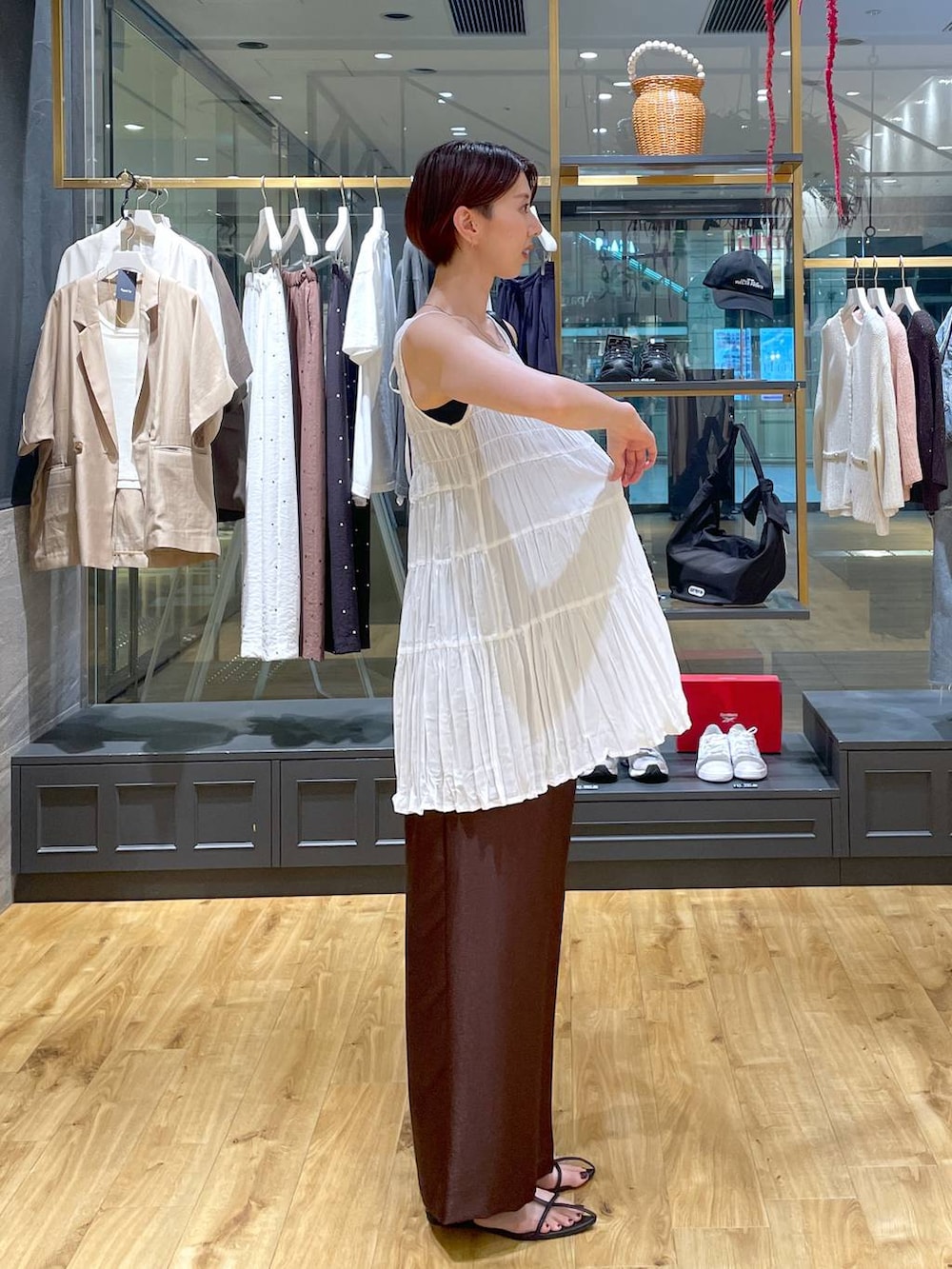 ブラウン系のその他パンツ、ブラック系のサンダル、ブラック系のハンドバッグを着用したレディースの夏コーディネートの2枚目の写真