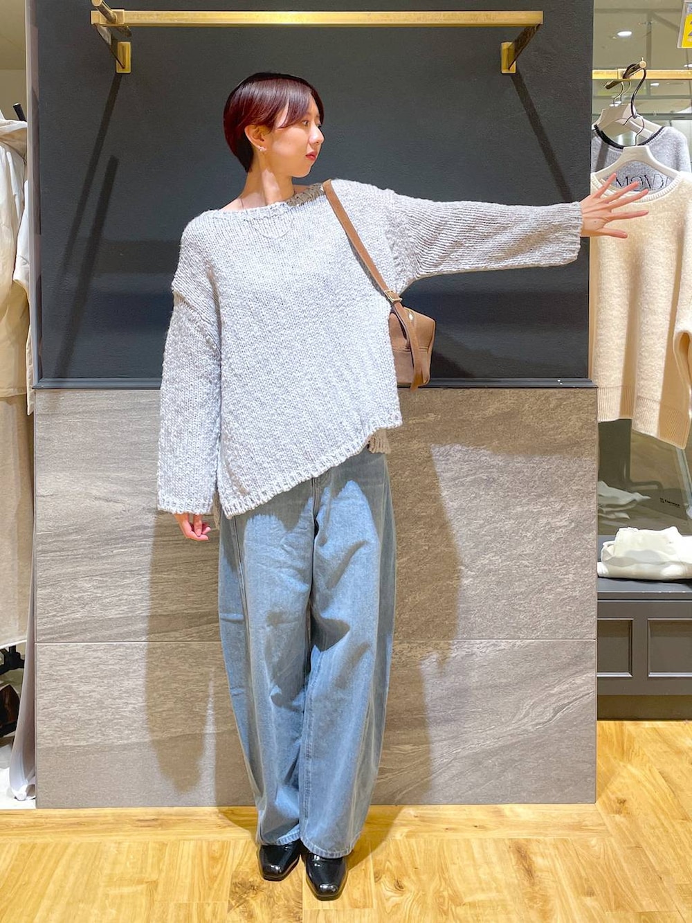 ブルー系のデニムパンツ、ブラック系のローファー、グレー系のニット/セーターを着用したレディースの秋コーディネートの2枚目の写真