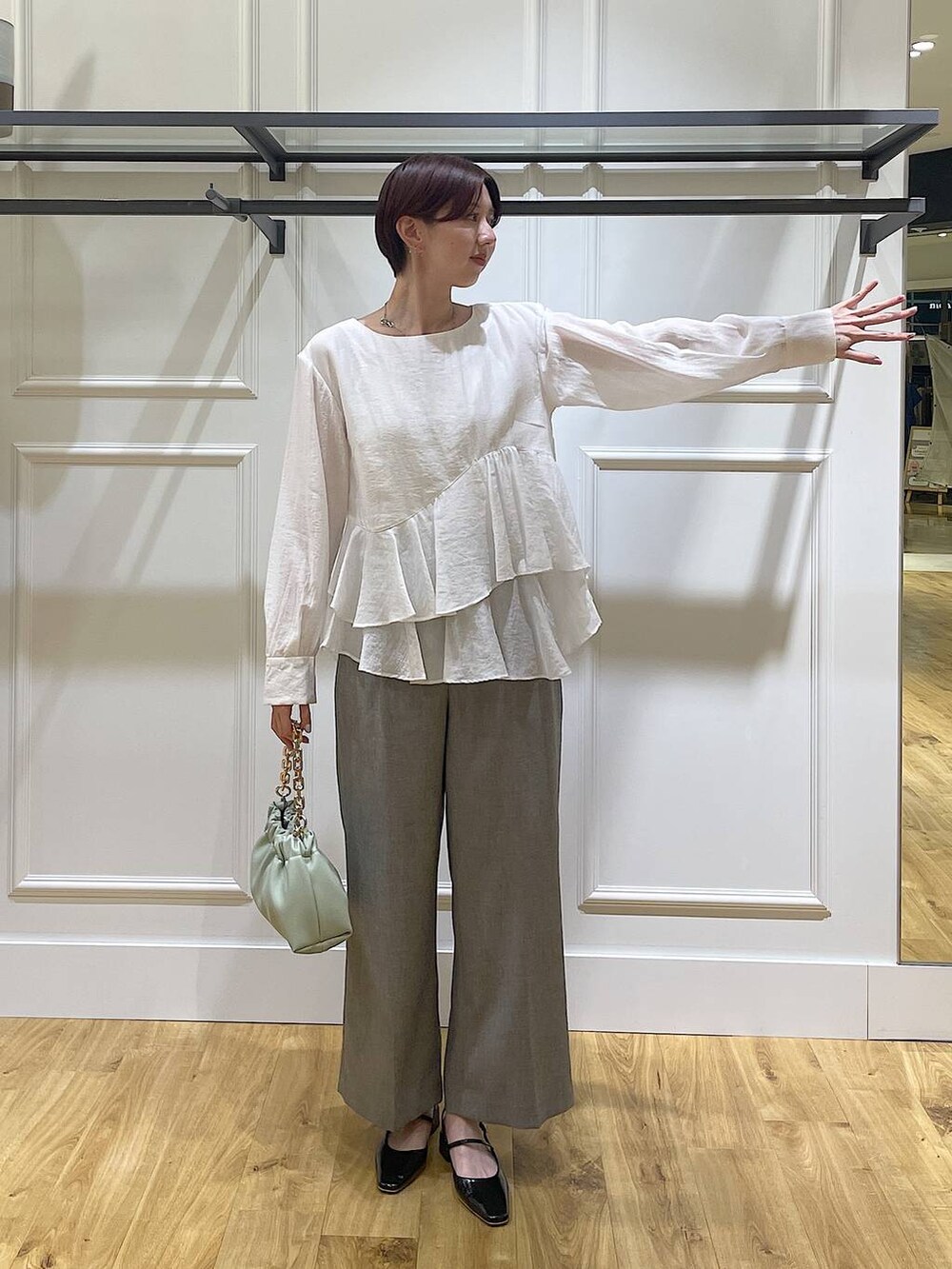 グリーン系のショルダーバッグ、ブラック系のその他パンツ、ホワイト系のシャツ/ブラウスを着用したレディースの春コーディネートの2枚目の写真