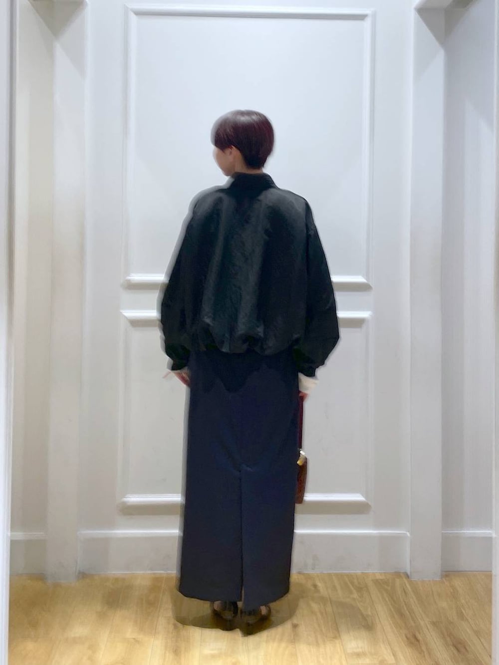 ブラック系のパンプス、ブルー系のスカート、ブラック系のブルゾンを着用したレディースの秋コーディネートの4枚目の写真