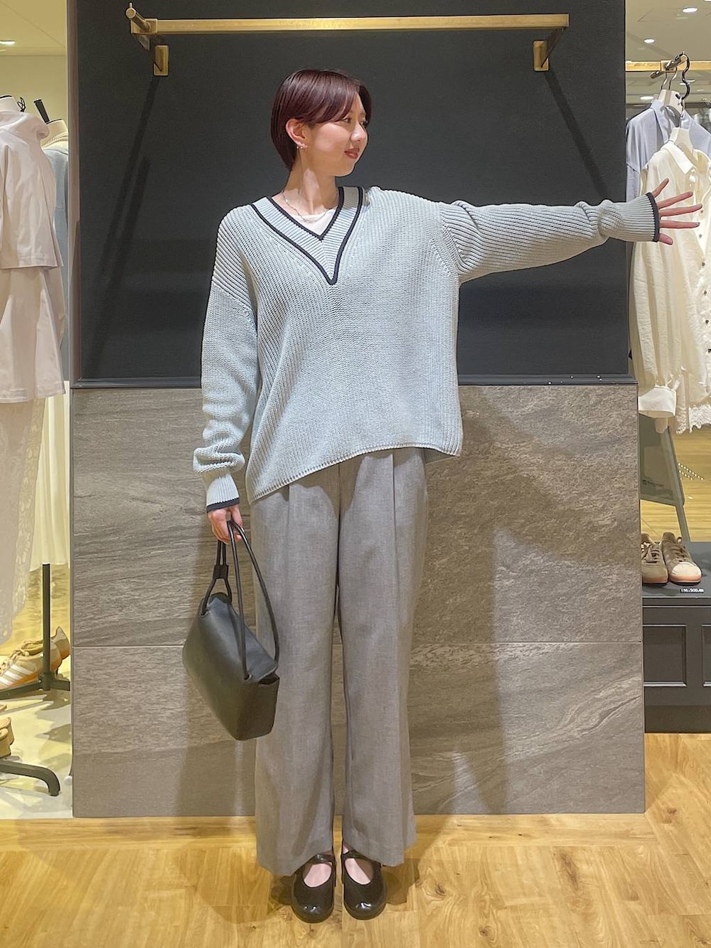 ブラック系のその他パンツ、ブラック系のショルダーバッグ、ブルー系のニット/セーターを着用したレディースの春コーディネートの2枚目の写真