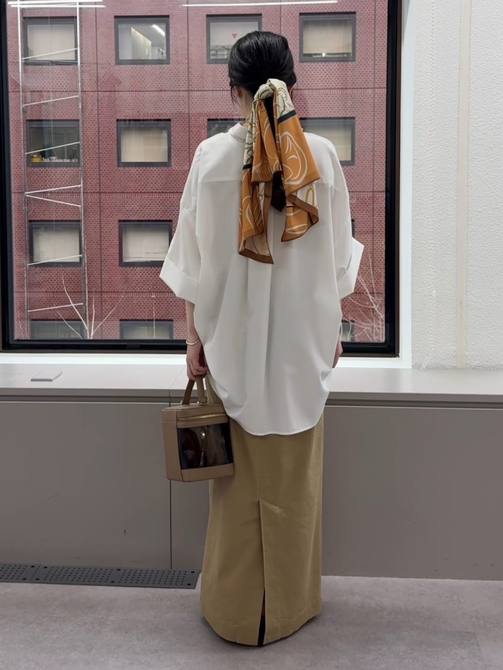 ホワイト系のシャツ/ブラウス、ベージュ系のスカート、ブラウン系のショルダーバッグを着用したレディースの春コーディネートの4枚目の写真