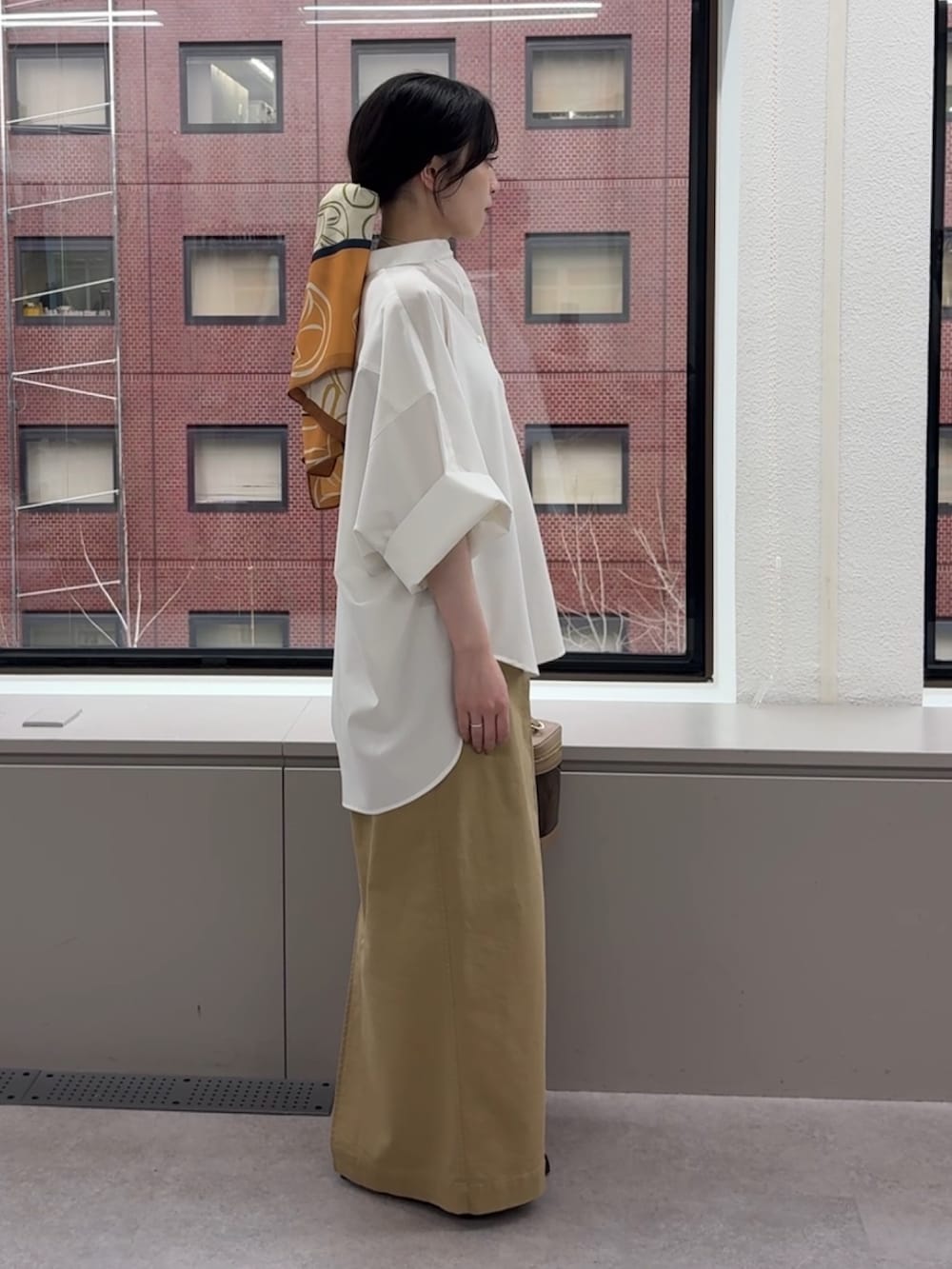 ホワイト系のシャツ/ブラウス、ベージュ系のスカート、ブラウン系のショルダーバッグを着用したレディースの春コーディネートの3枚目の写真