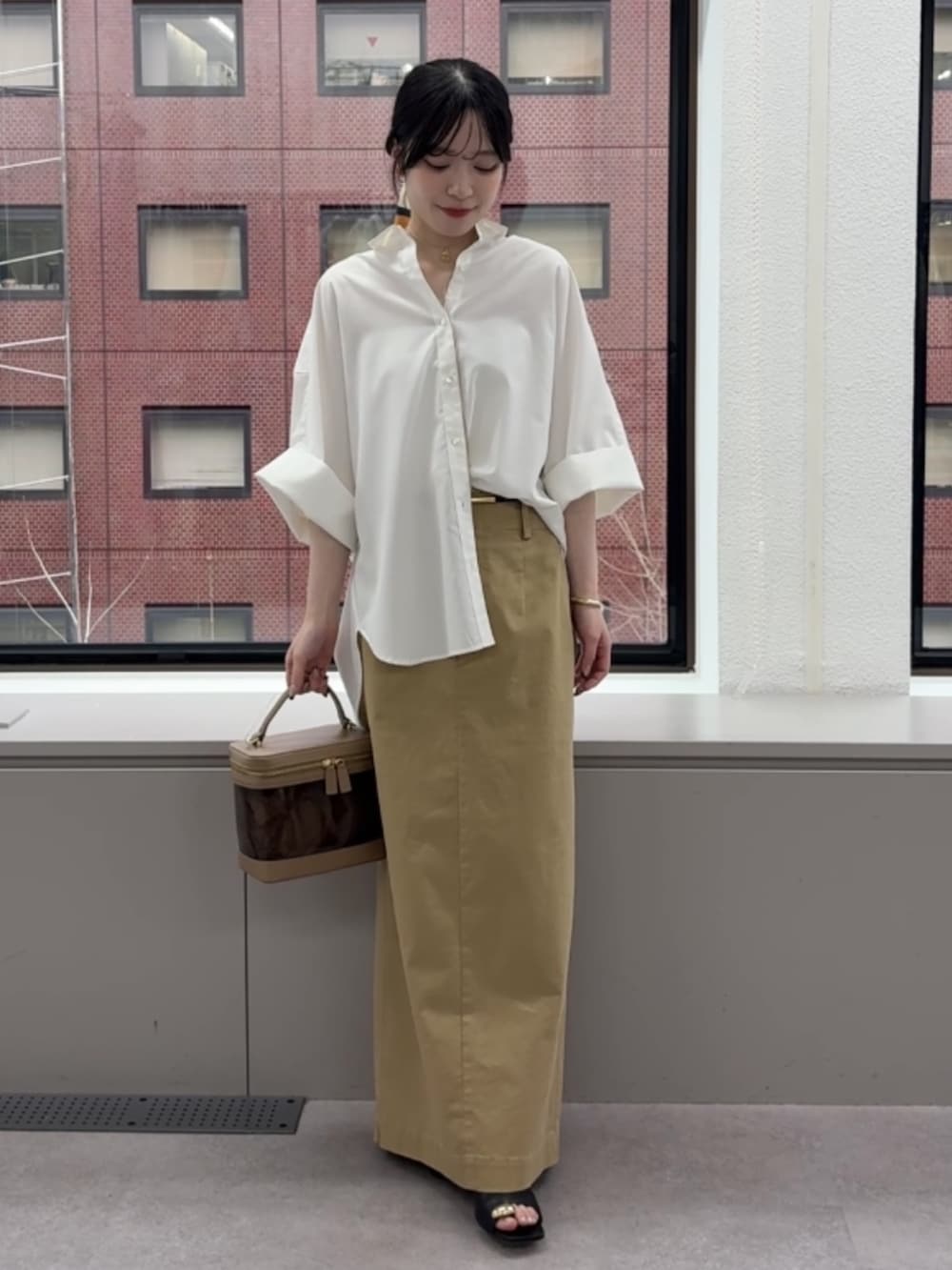 ホワイト系のシャツ/ブラウス、ベージュ系のスカート、ブラウン系のショルダーバッグを着用したレディースの春コーディネートの2枚目の写真