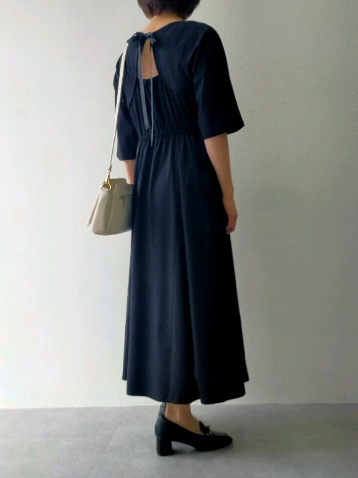 ブラック系のワンピース、ブラック系のローファー、ホワイト系のショルダーバッグを着用したレディースの春コーディネートの2枚目の写真