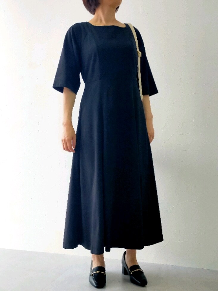 ブラック系のワンピース、ブラック系のローファー、ホワイト系のショルダーバッグを着用したレディースの春コーディネートの3枚目の写真