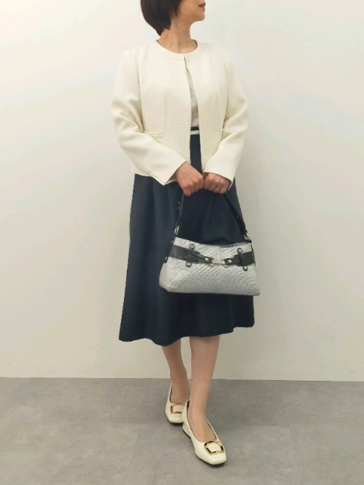 ブラック系のスーツセット、グレー系のバッグ、ホワイト系のパンプスを着用したレディースの冬コーディネートの2枚目の写真