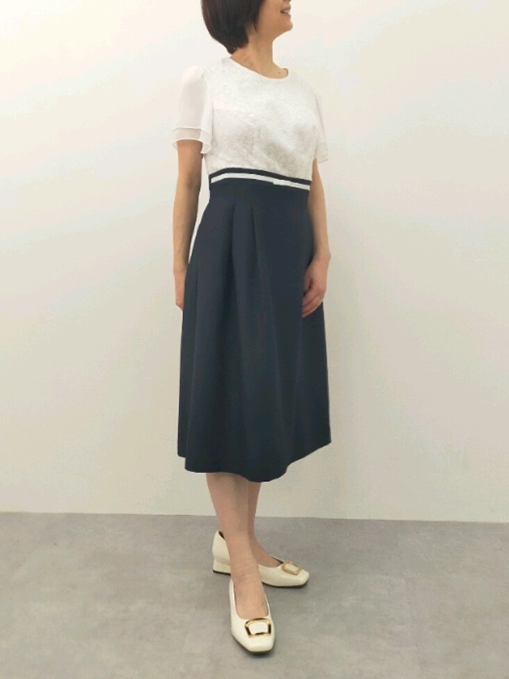 ブラック系のスーツセット、グレー系のバッグ、ホワイト系のパンプスを着用したレディースの冬コーディネートの3枚目の写真