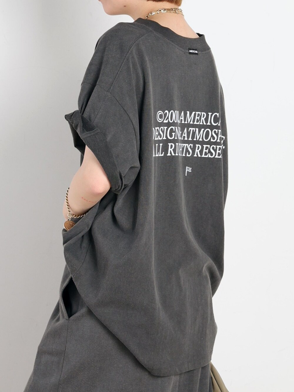ベージュ系のナイロンジャケット、ブラック系のスカート、ブラック系のTシャツ/カットソーを着用したレディースの春コーディネートの5枚目の写真