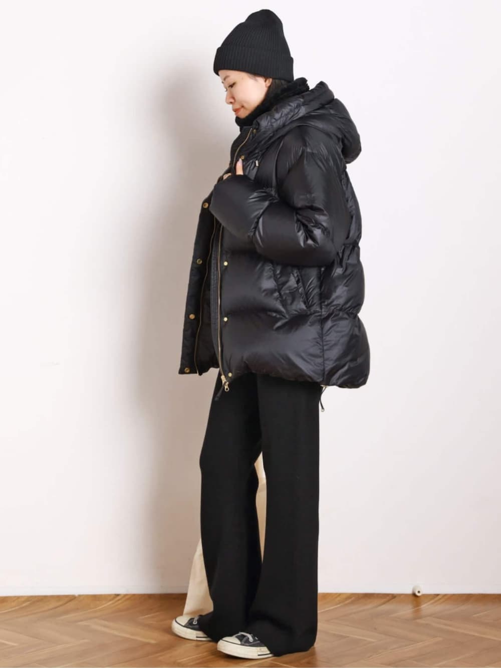 ホワイト系のTシャツ/カットソー、ブラック系のその他パンツ、ブラック系のダウンジャケット/コートを着用したレディースの秋コーディネートの2枚目の写真