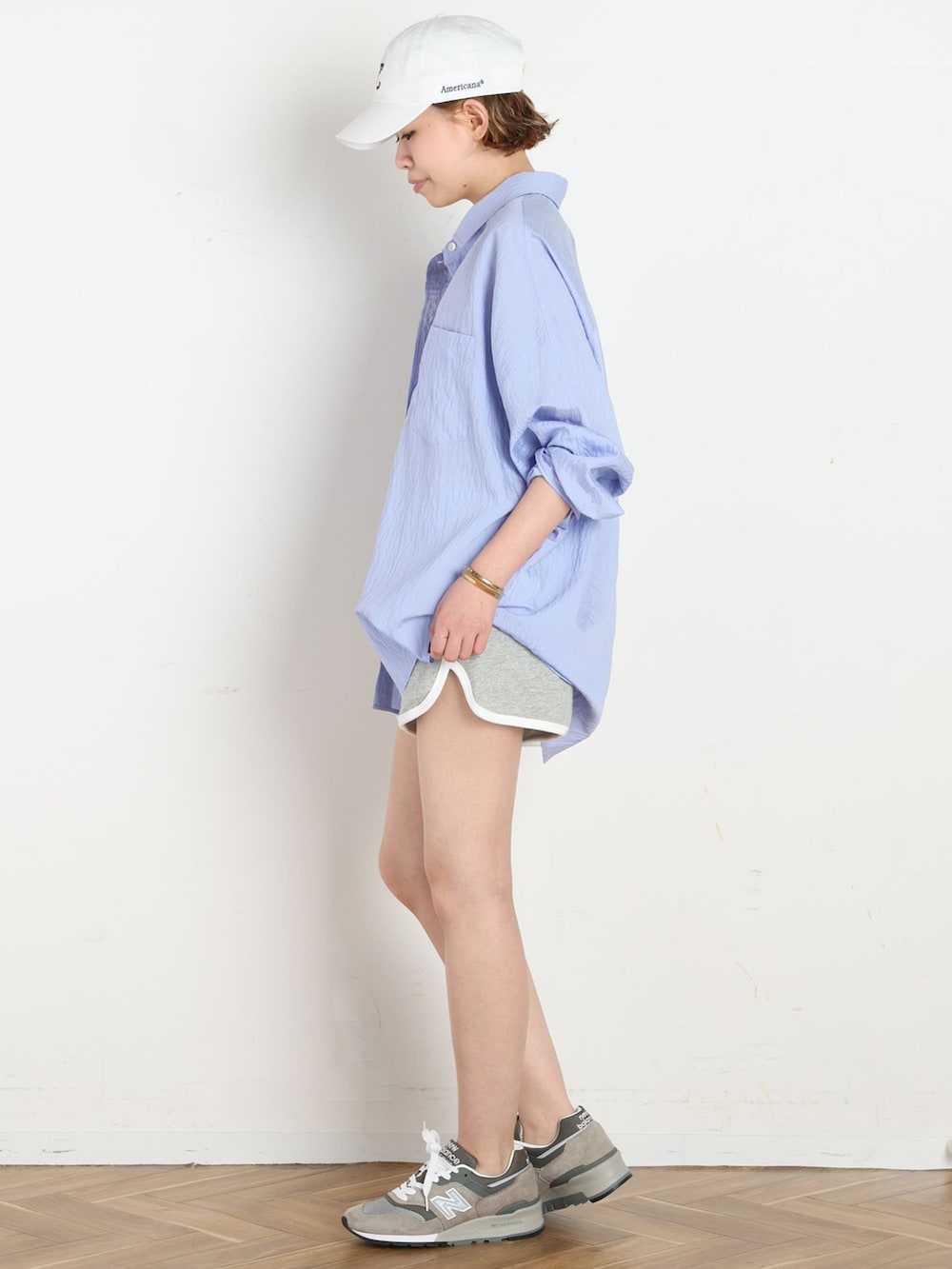 グレー系のその他パンツ、ブルー系のシャツ/ブラウス、ホワイト系のキャップを着用したレディースの春コーディネートの2枚目の写真