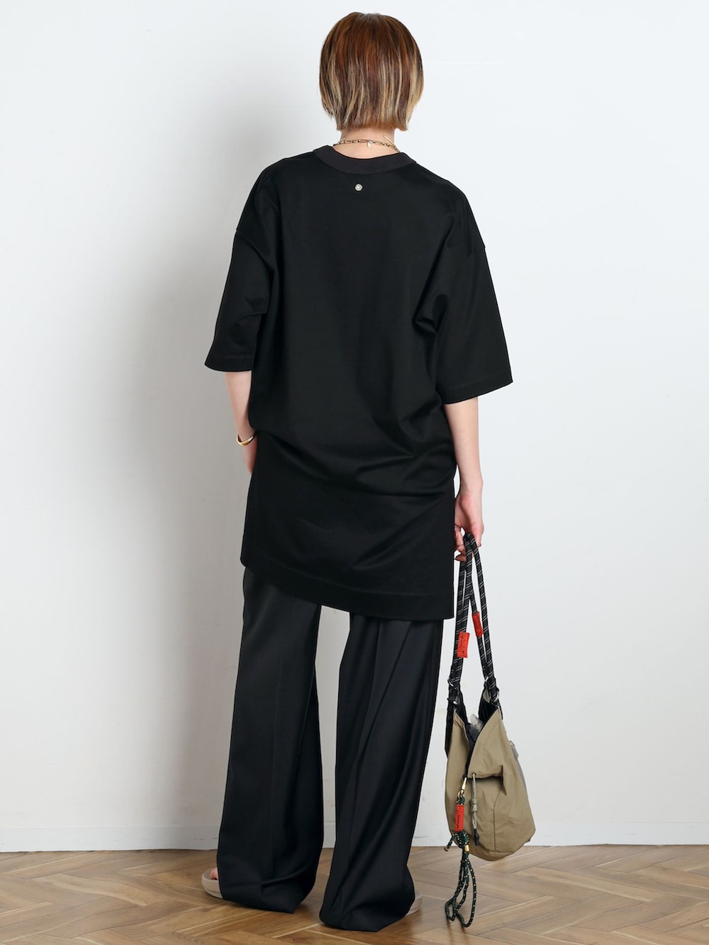ブラック系のスラックス、ブラック系のTシャツ/カットソー、ベージュ系のサンダルを着用したレディースの春コーディネートの3枚目の写真