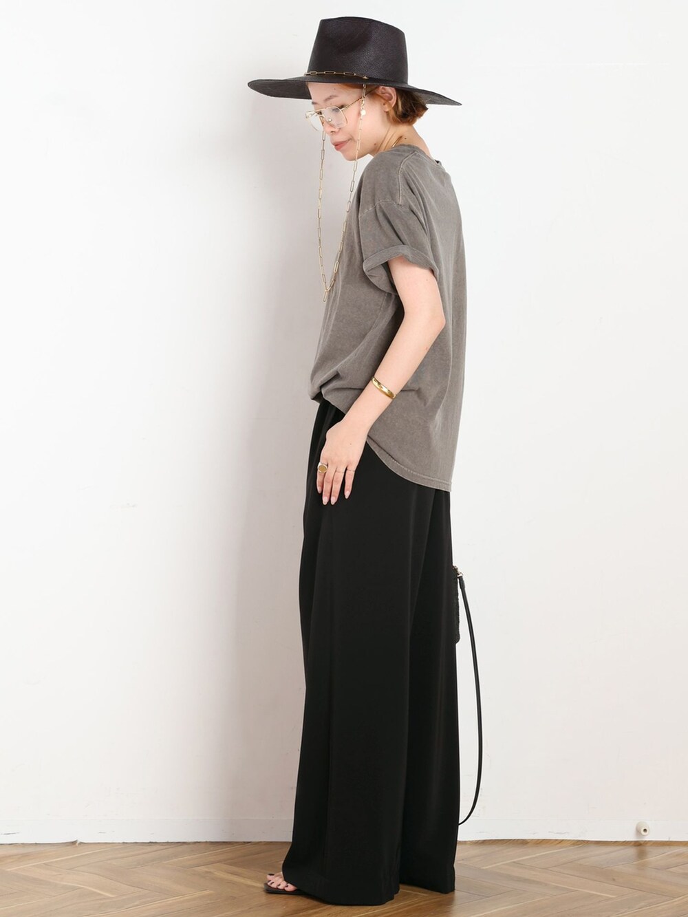 ブラック系のスラックス、グリーン系のTシャツ/カットソー、ブラック系のショルダーバッグを着用したレディースの夏コーディネートの2枚目の写真