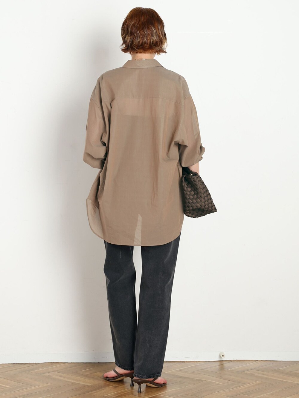 ブラック系のデニムパンツ、ベージュ系のシャツ/ブラウス、ブラウン系のクラッチバッグを着用したレディースの春コーディネートの3枚目の写真