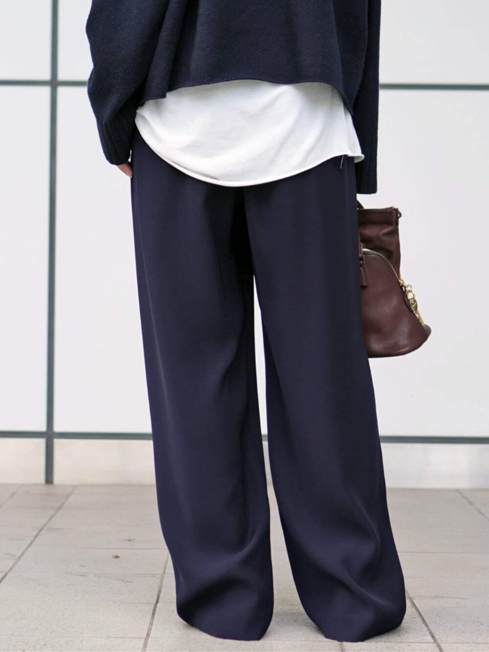 ブルー系のスラックス、ホワイト系のTシャツ/カットソーを着用したレディースの秋コーディネートの6枚目の写真