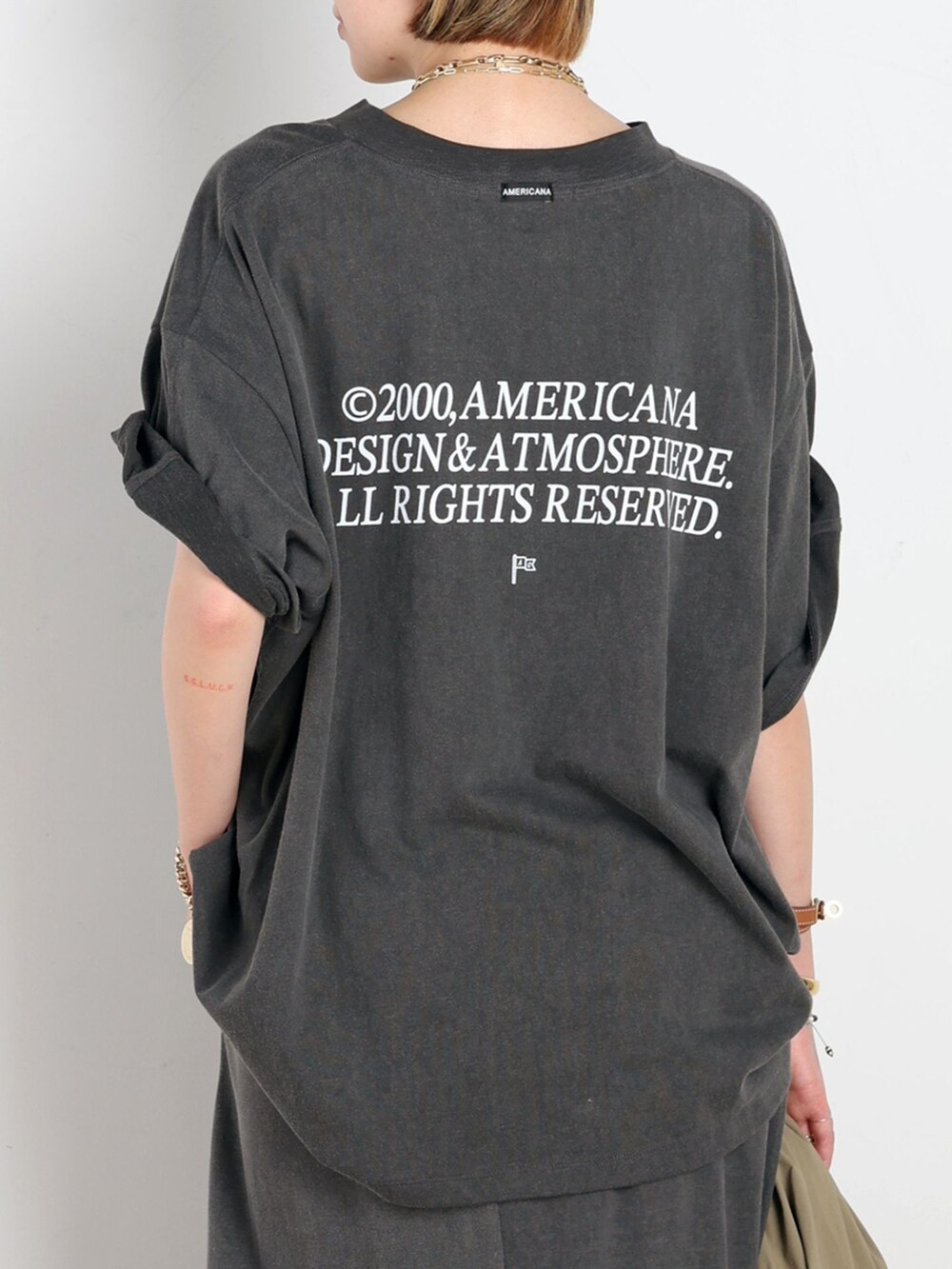 ベージュ系のナイロンジャケット、ブラック系のスカート、ブラック系のTシャツ/カットソーを着用したレディースの春コーディネートの6枚目の写真