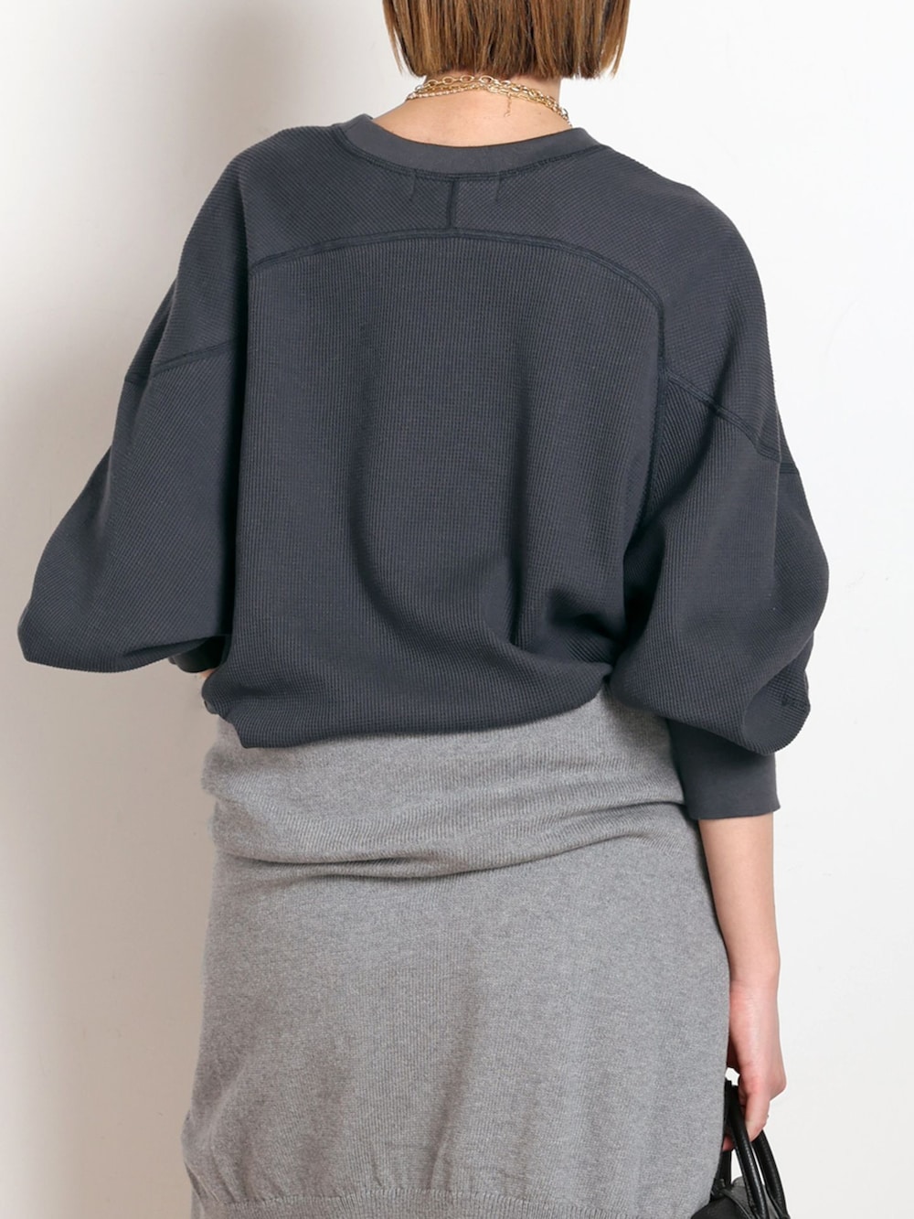 ホワイト系のデニムパンツ、ブラック系のTシャツ/カットソー、グレー系のニット/セーターを着用したレディースの冬コーディネートの6枚目の写真