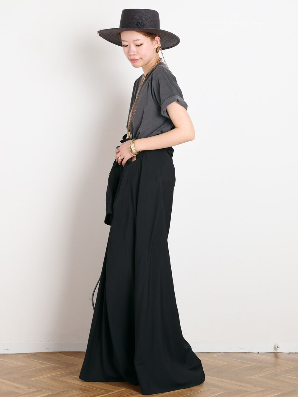 ブラック系のワンピース、ブラック系のTシャツ/カットソー、ブラウン系のサンダルを着用したレディースの春コーディネートの2枚目の写真