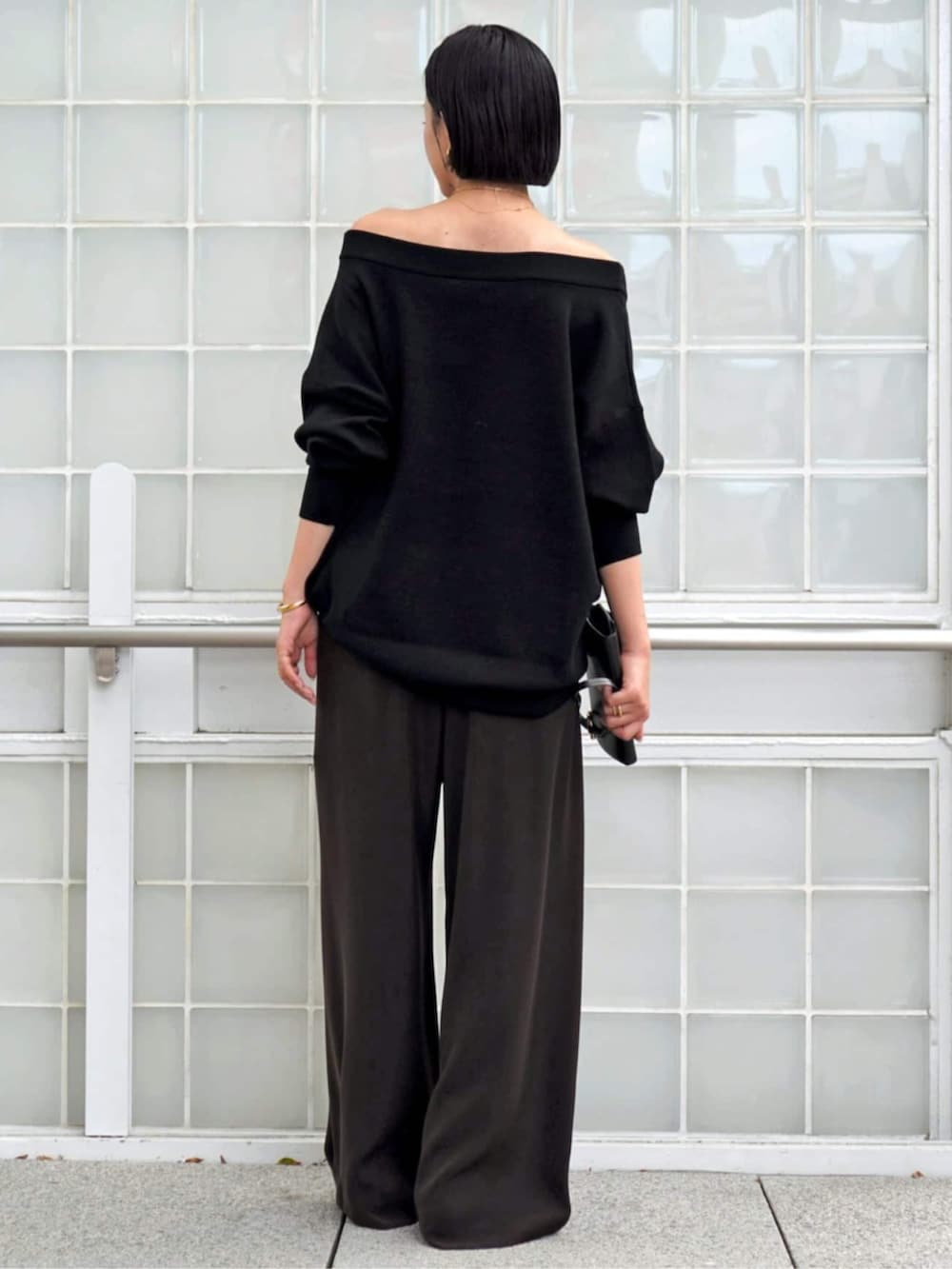 ブラック系のニット/セーター、ブラウン系のスラックス、イエロー系のブーツを着用したレディースの秋コーディネートの3枚目の写真