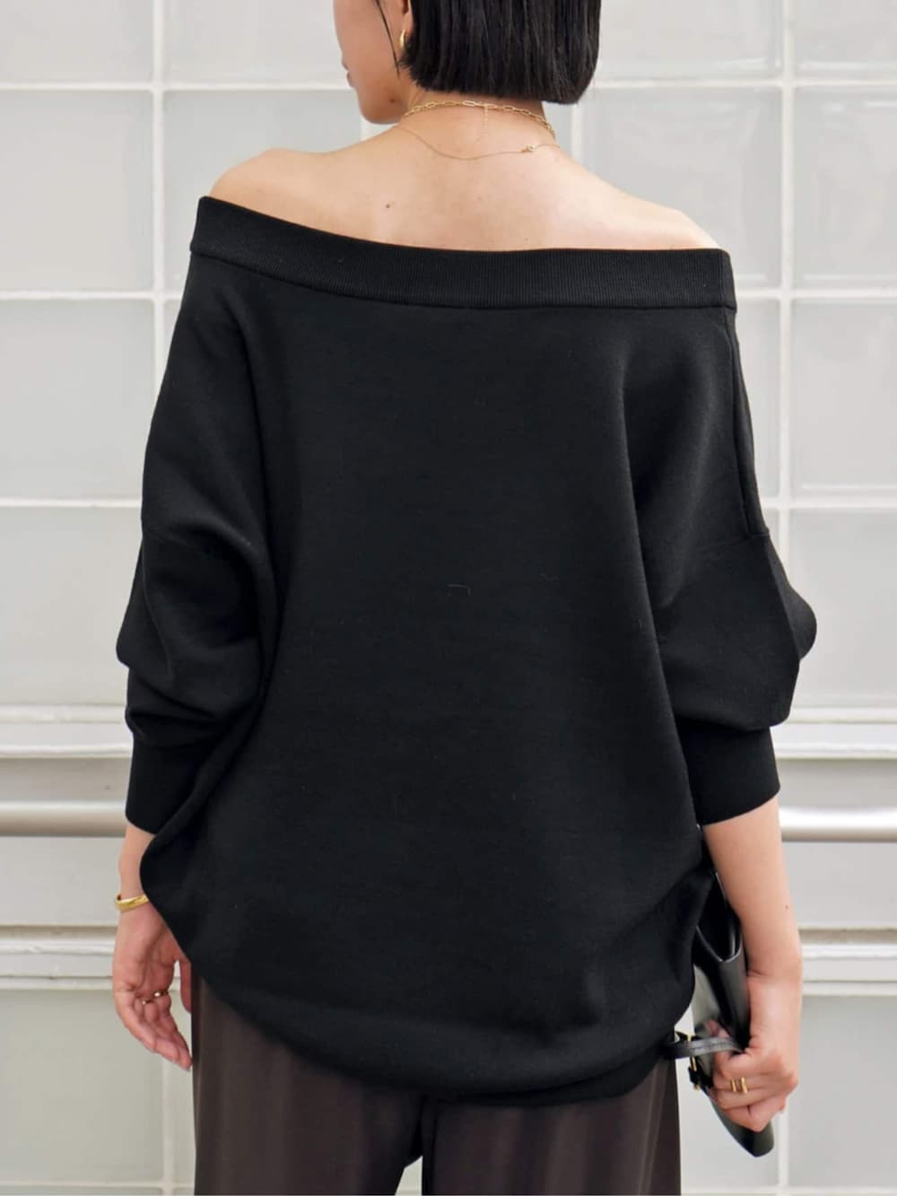 ブラック系のニット/セーター、ブラウン系のスラックス、イエロー系のブーツを着用したレディースの秋コーディネートの6枚目の写真