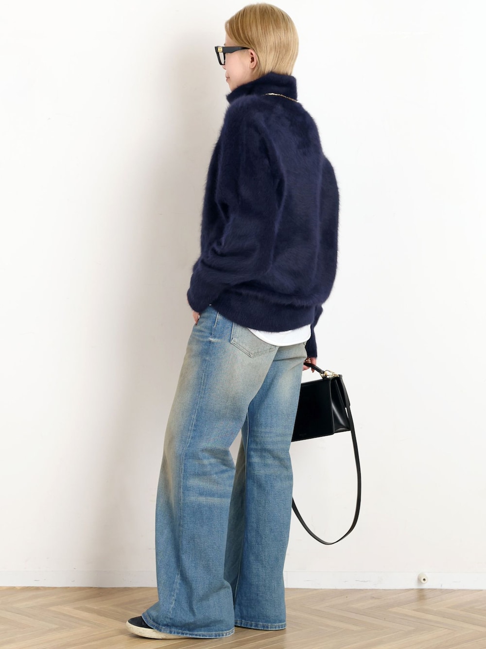 ブラック系のその他アウター、ブルー系のデニムパンツ、ブルー系のニット/セーターを着用したレディースの秋コーディネートの5枚目の写真