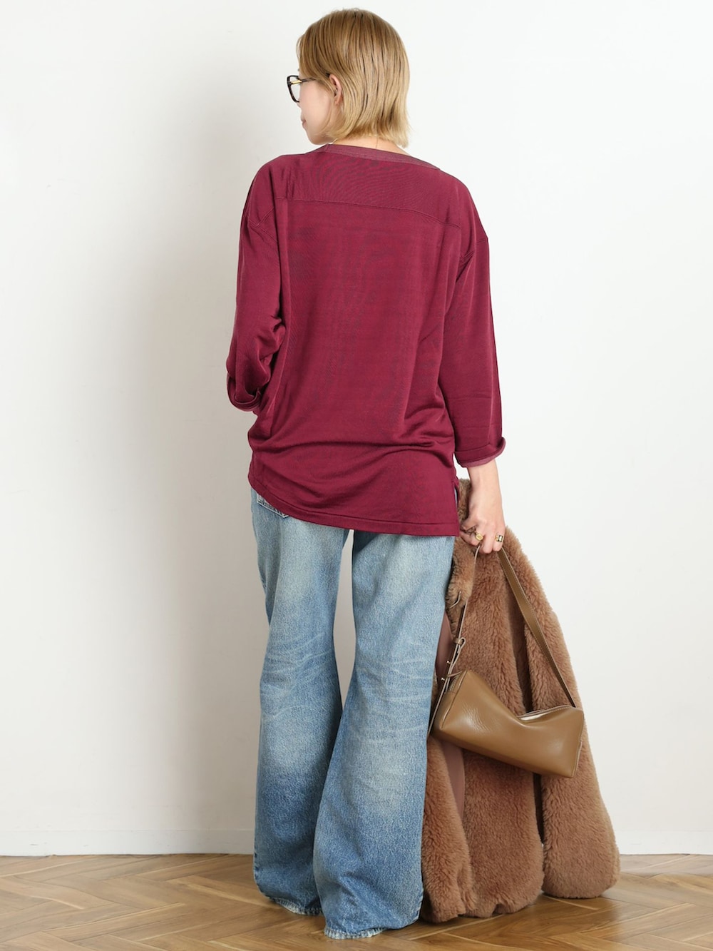 ブルー系のデニムパンツ、レッド系のTシャツ/カットソー、ゴールド系のブレスレットを着用したレディースの秋コーディネートの3枚目の写真