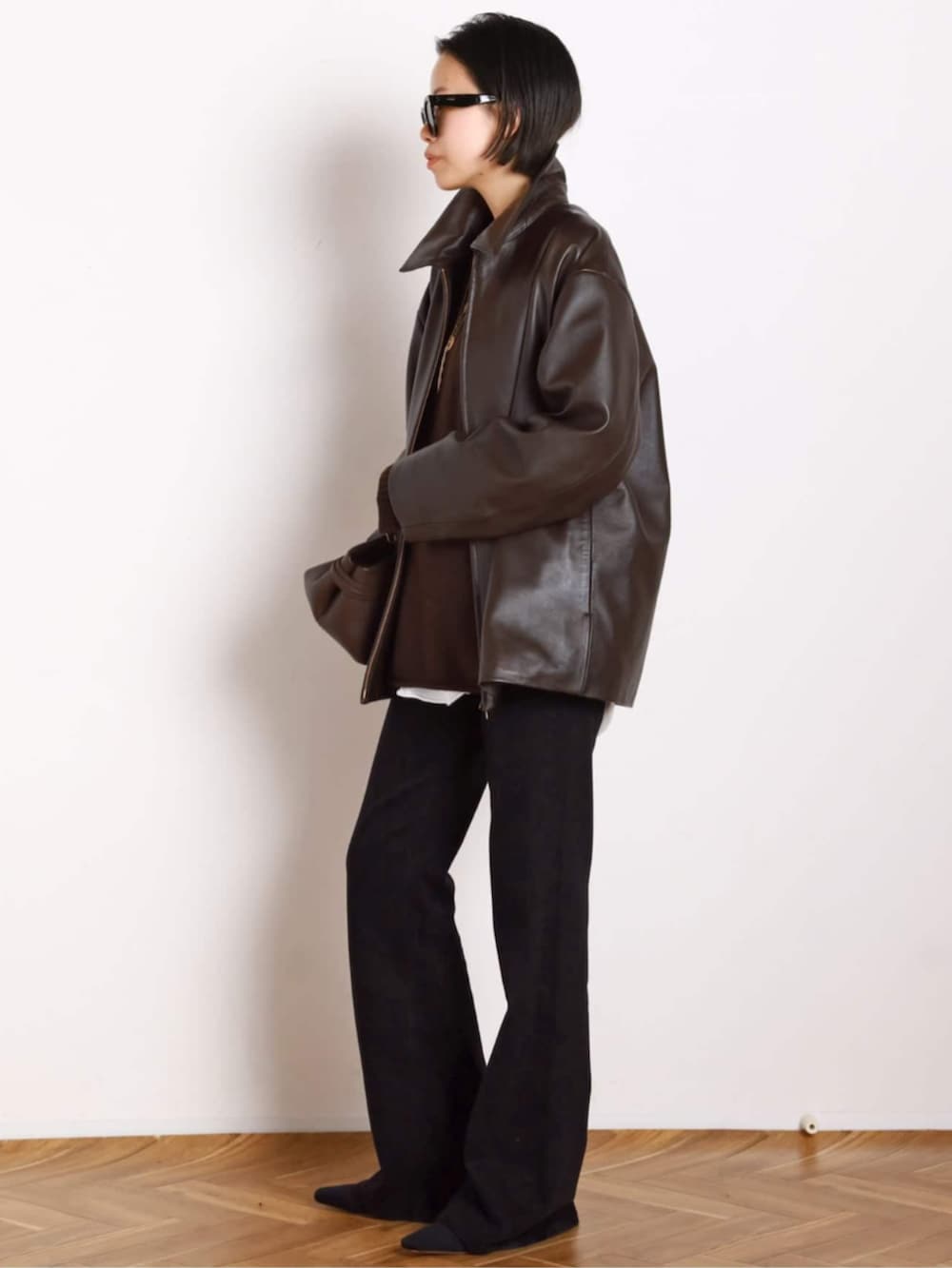 ブラック系のブーツ、ブラウン系のその他アウター、ブラウン系のトートバッグを着用したレディースの秋コーディネートの2枚目の写真