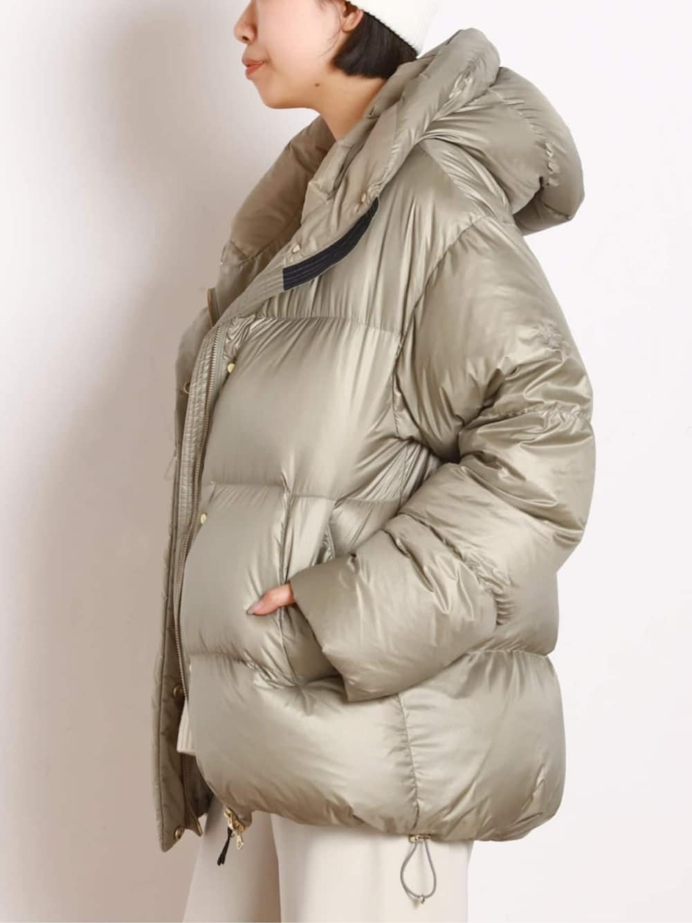 ベージュ系のダウンジャケット/コート、ホワイト系のスラックスを着用したレディースの秋コーディネートの5枚目の写真
