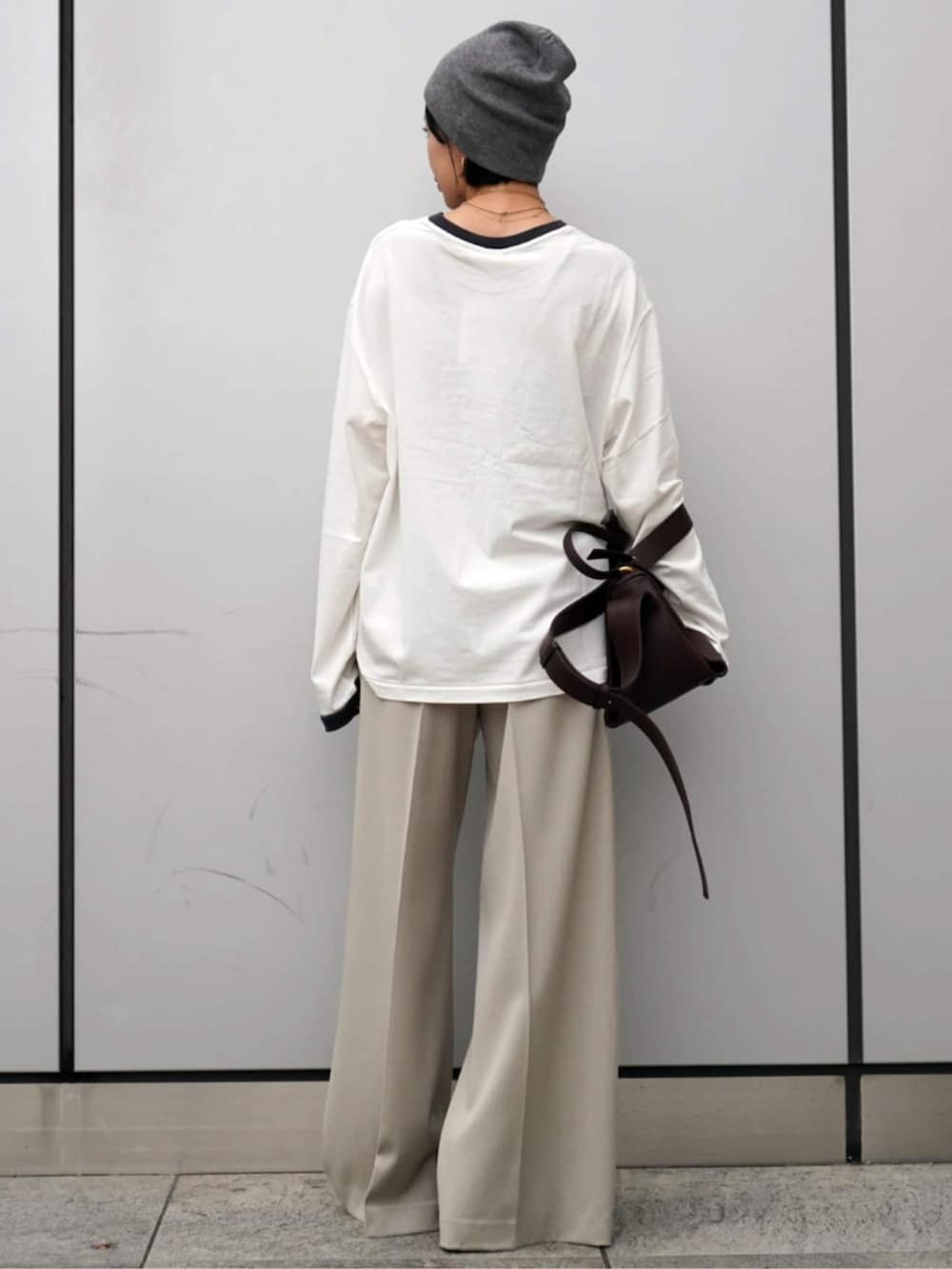 ホワイト系のスラックス、グレー系のニットキャップ/ビーニーを着用したレディースの秋コーディネートの3枚目の写真
