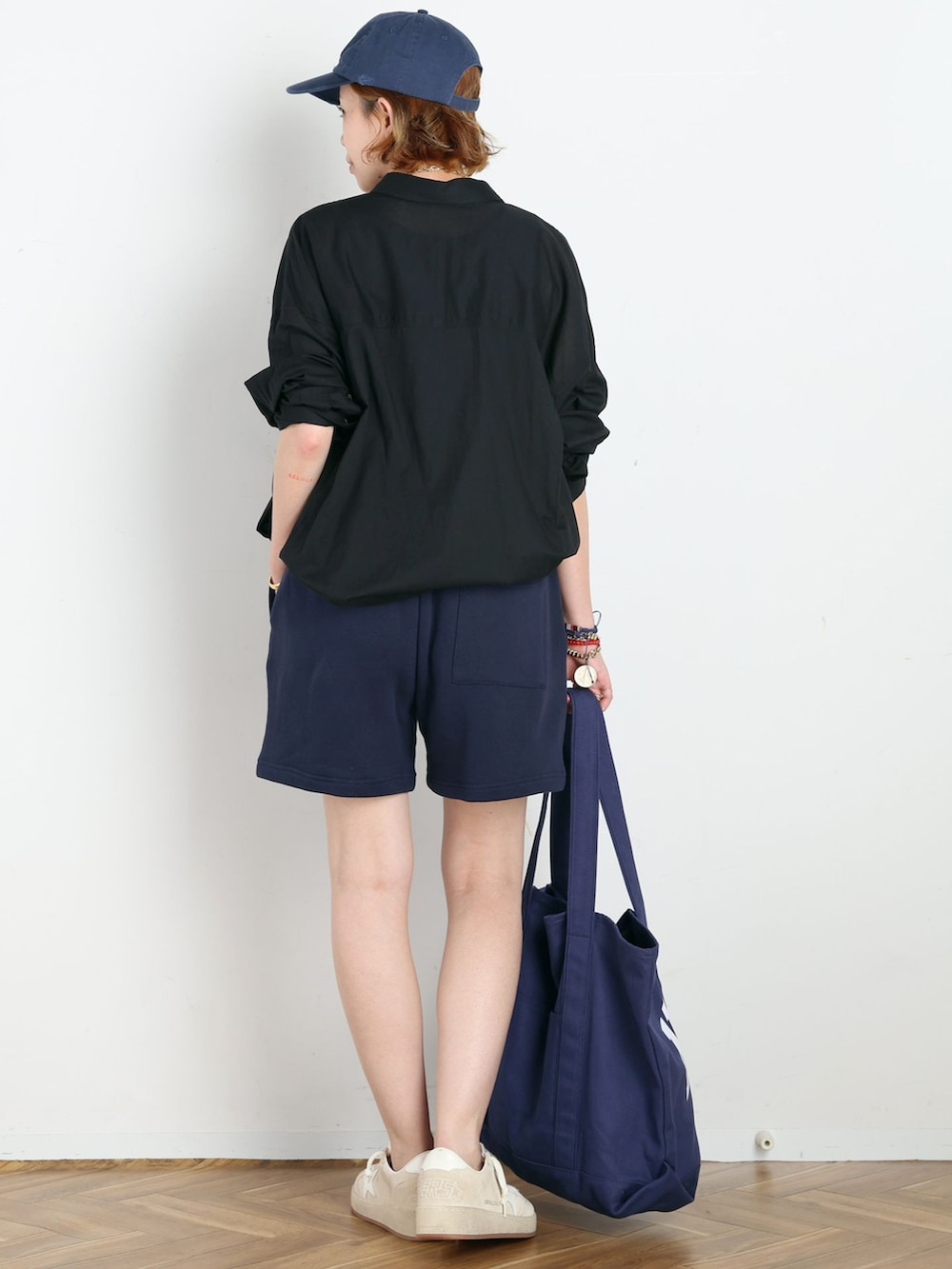 ブルー系のスウェットパンツ、ブラック系のタンクトップ、ブルー系のトートバッグを着用したレディースの夏コーディネートの3枚目の写真