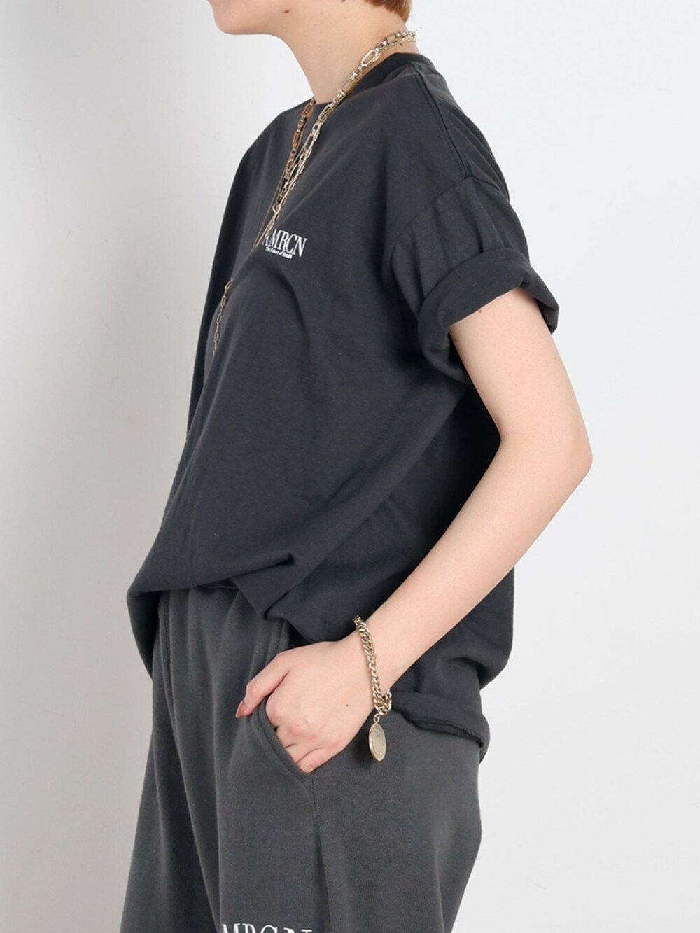 ブラック系のスウェットパンツ、ブラック系のTシャツ/カットソー、ゴールド系のネックレスを着用したレディースの春コーディネートの5枚目の写真