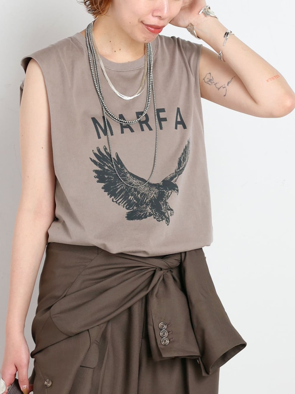 グリーン系のテーラードジャケット、グリーン系のスラックス、ベージュ系のTシャツ/カットソーを着用したレディースの夏コーディネートの4枚目の写真