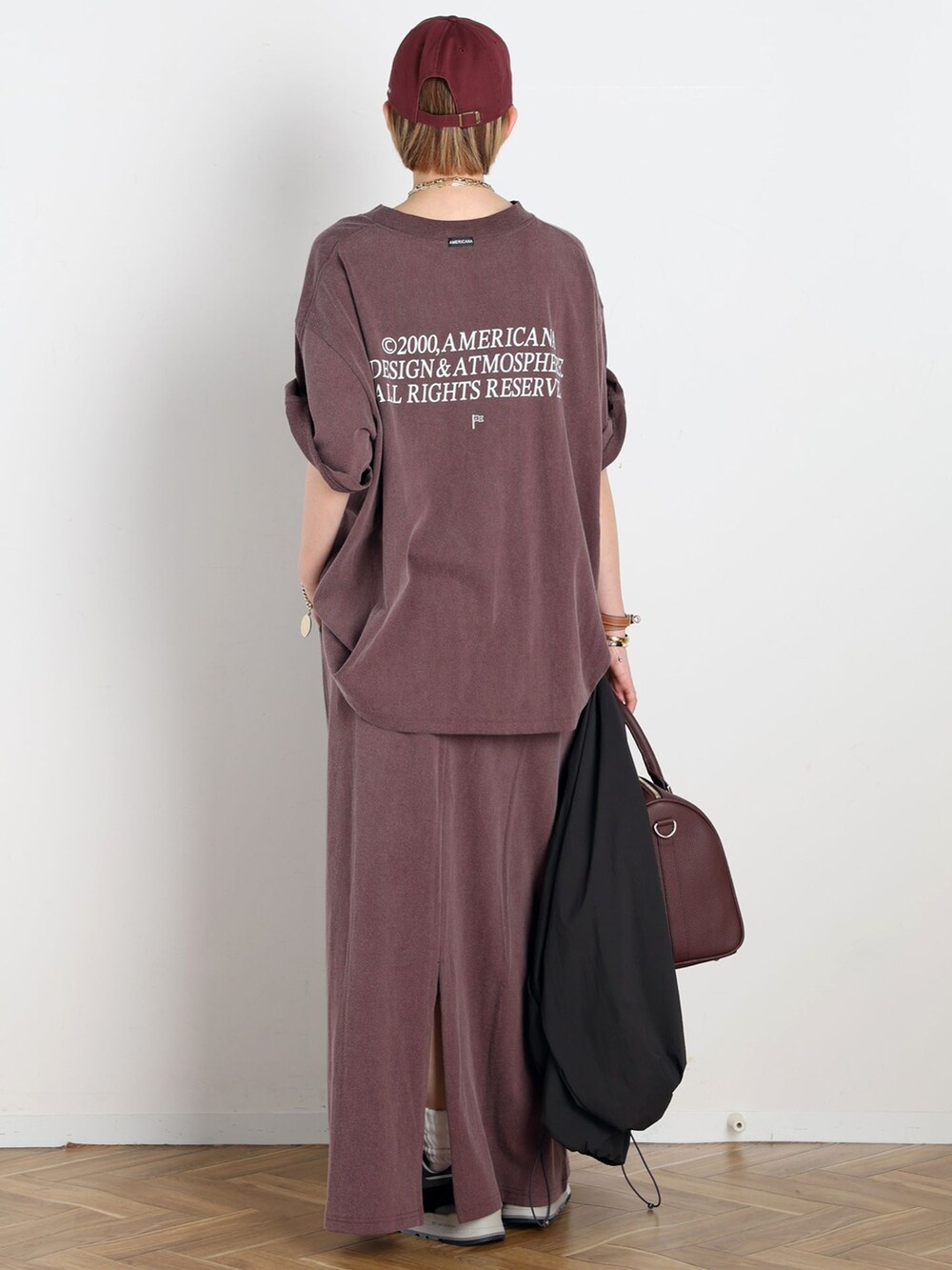 ブラック系のナイロンジャケット、レッド系のスカート、レッド系のTシャツ/カットソーを着用したレディースの春コーディネートの3枚目の写真