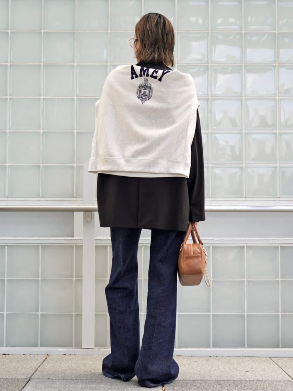 ブラウン系のテーラードジャケット、ブラウン系のニット/セーター、イエロー系のハンドバッグを着用したレディースの秋コーディネートの3枚目の写真