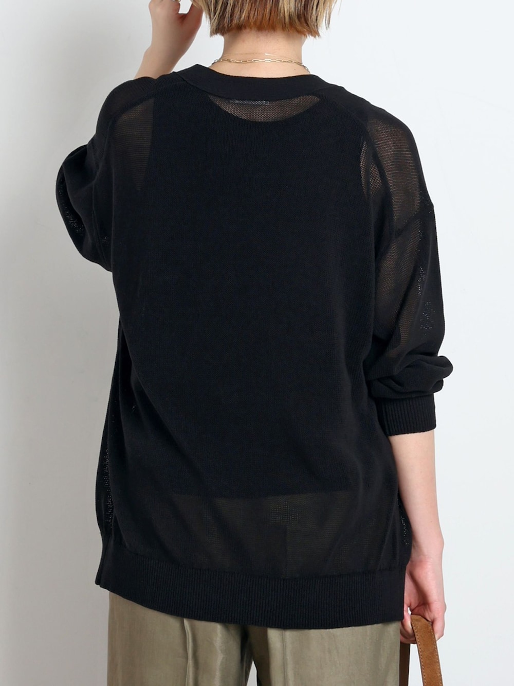 グリーン系のスラックス、ブラック系のTシャツ/カットソー、ブラック系のカーディガン/ボレロを着用したレディースの春コーディネートの6枚目の写真