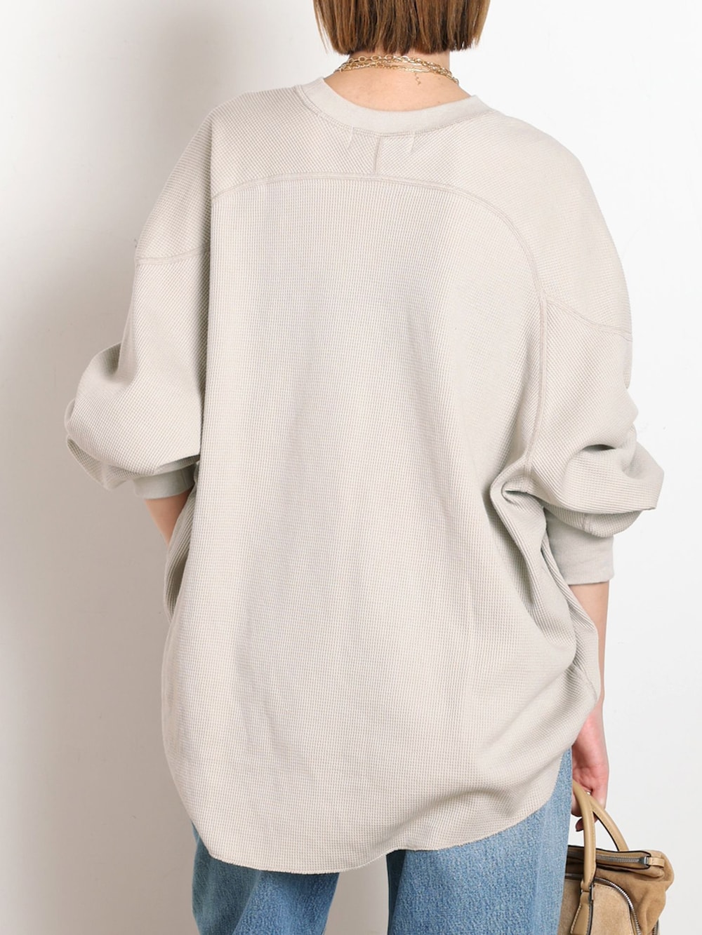 ブルー系のデニムパンツ、ベージュ系のTシャツ/カットソー、ゴールド系のサンダルを着用したレディースの冬コーディネートの6枚目の写真