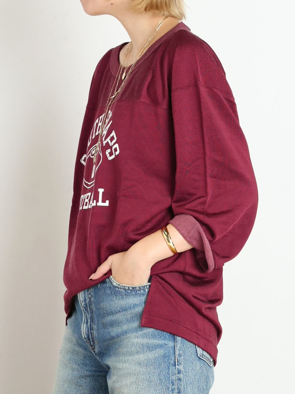 ブルー系のデニムパンツ、レッド系のTシャツ/カットソー、ゴールド系のブレスレットを着用したレディースの秋コーディネートの5枚目の写真