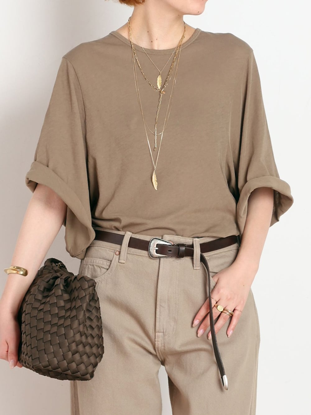 イエロー系のTシャツ/カットソー、ブラウン系のクラッチバッグ、ブラウン系のサンダルを着用したレディースの夏コーディネートの4枚目の写真