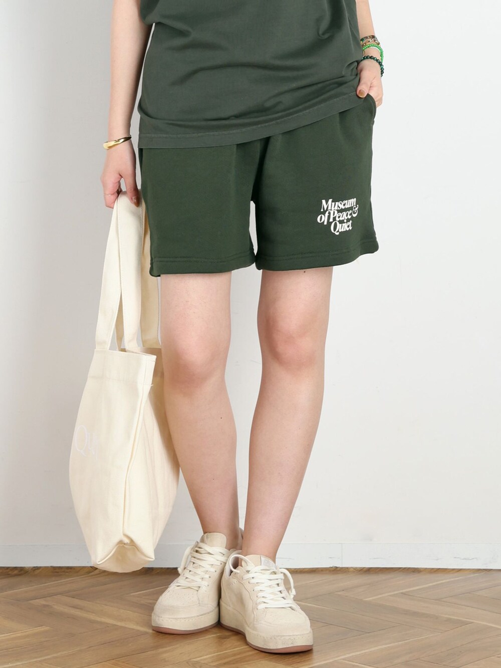 グリーン系のスウェットパンツ、グリーン系のTシャツ/カットソー、ホワイト系のトートバッグを着用したレディースの夏コーディネートの4枚目の写真