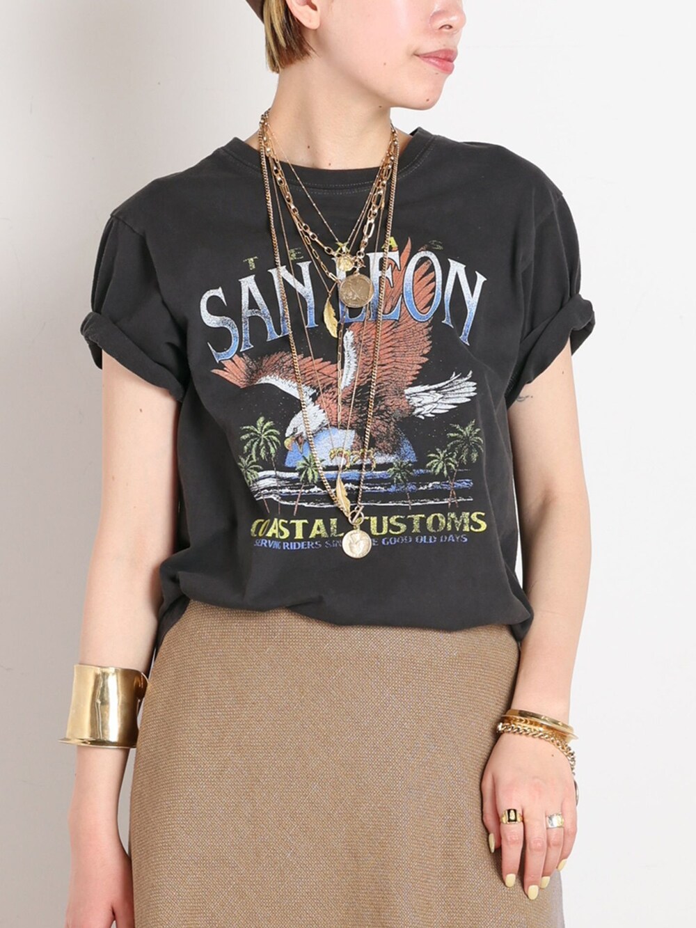 イエロー系のスカート、ブラック系のTシャツ/カットソー、ゴールド系のサンダルを着用したレディースの春コーディネートの4枚目の写真