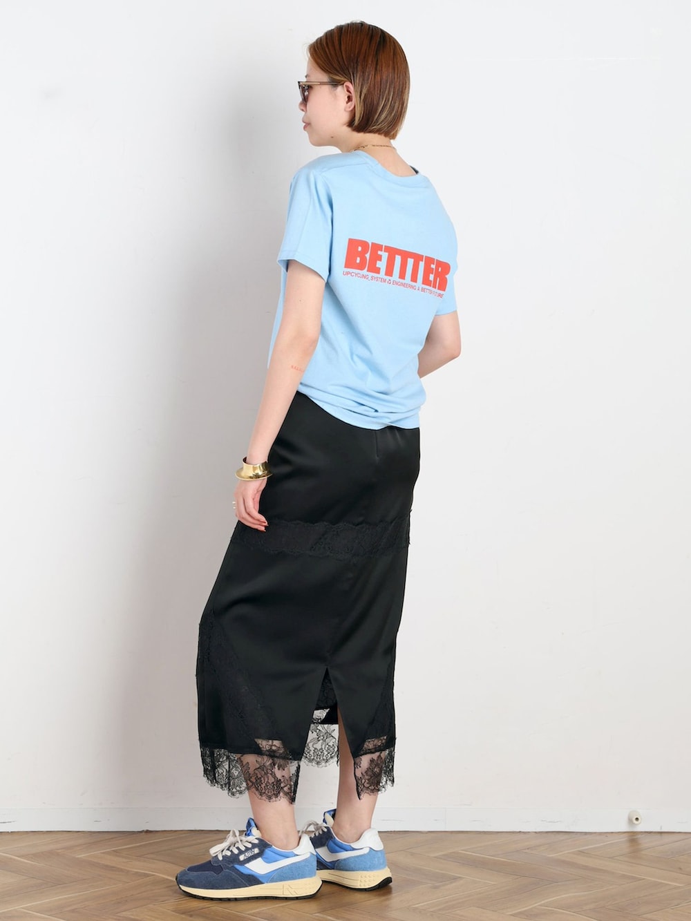 ブラック系のスカート、ブルー系のTシャツ/カットソー、ブルー系のスニーカーを着用したレディースの春コーディネートの2枚目の写真