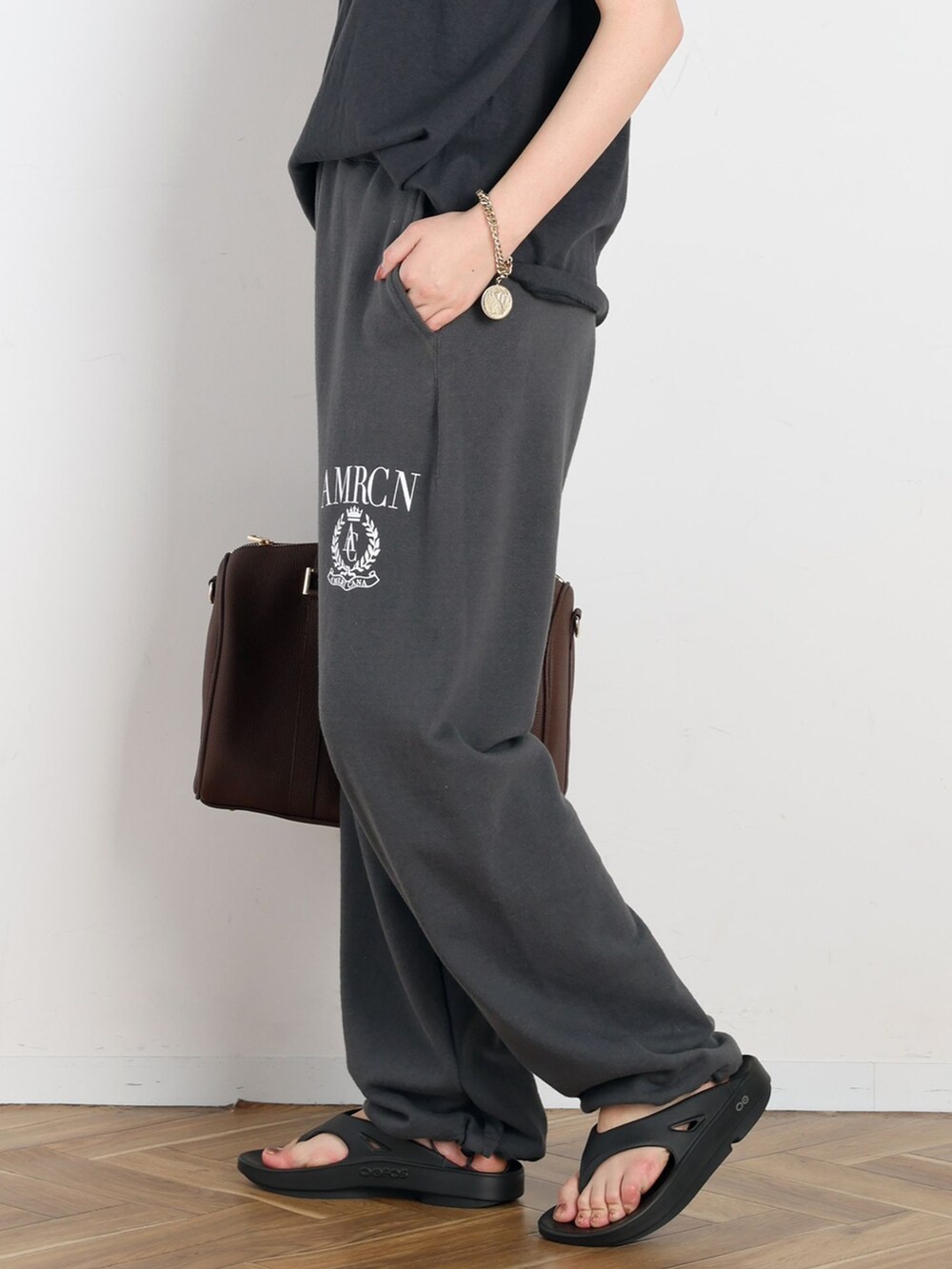 ブラック系のスウェットパンツ、ブラック系のTシャツ/カットソー、ゴールド系のネックレスを着用したレディースの春コーディネートの8枚目の写真