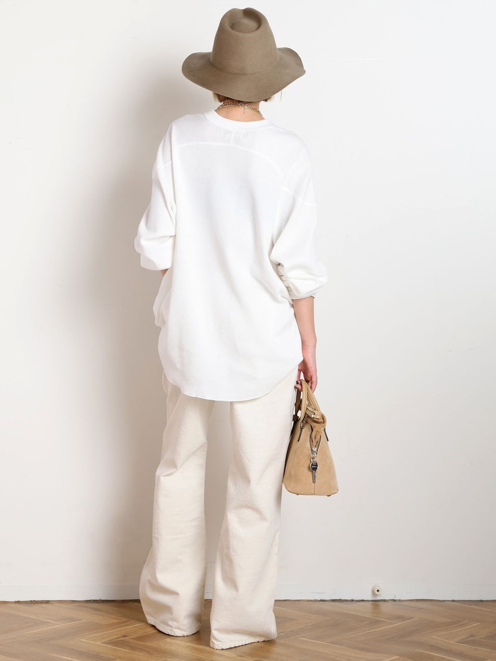 ホワイト系のデニムパンツ、ホワイト系のTシャツ/カットソー、ゴールド系のブレスレットを着用したレディースの冬コーディネートの3枚目の写真