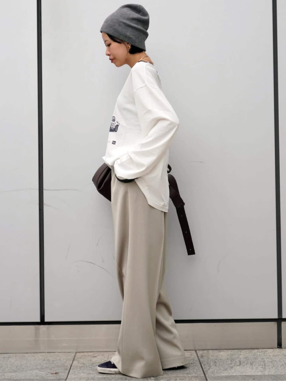 ホワイト系のスラックス、グレー系のニットキャップ/ビーニーを着用したレディースの秋コーディネートの2枚目の写真
