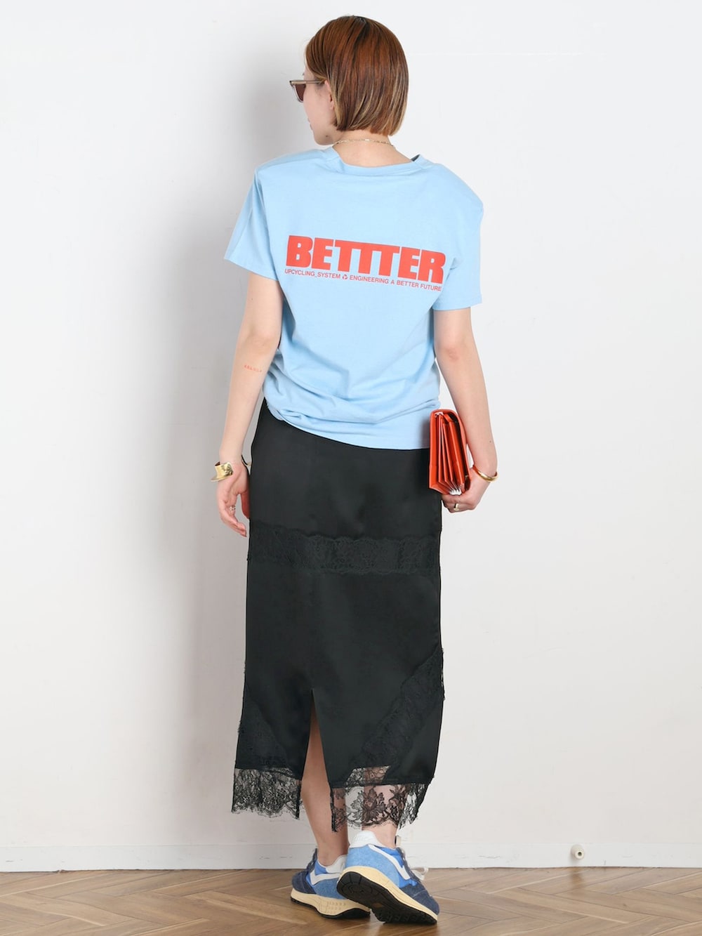 ブラック系のスカート、ブルー系のTシャツ/カットソー、ブルー系のスニーカーを着用したレディースの春コーディネートの3枚目の写真