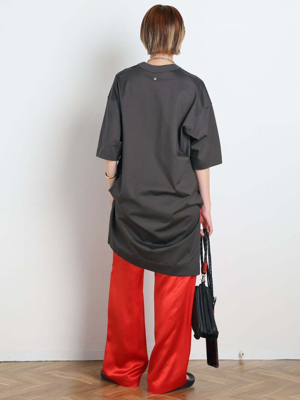 レッド系のその他パンツ、グレー系のTシャツ/カットソー、ブラック系のショルダーバッグを着用したレディースの春コーディネートの3枚目の写真