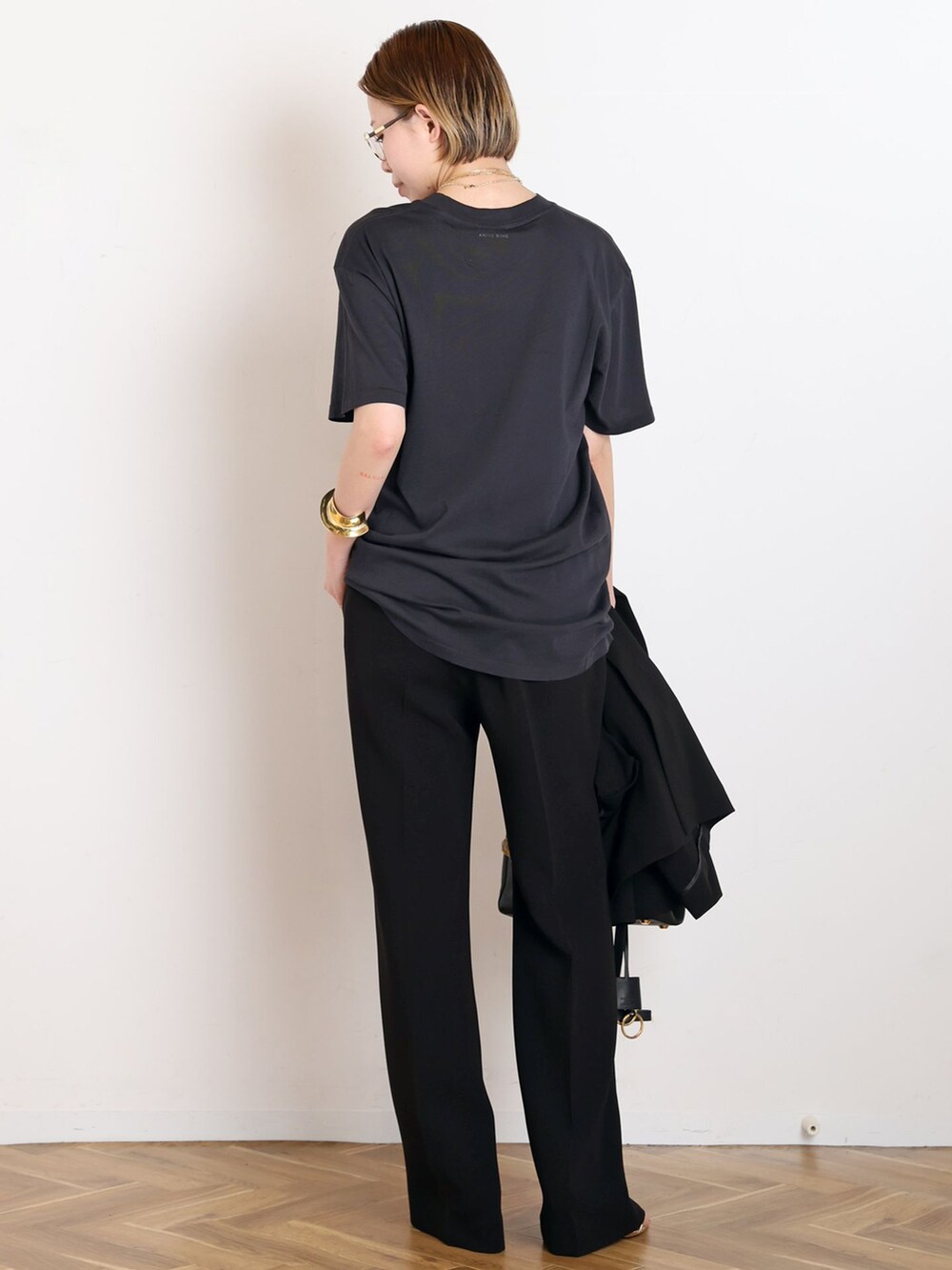 ブラック系のテーラードジャケット、ブラック系のスラックス、ブラック系のTシャツ/カットソーを着用したレディースの春コーディネートの6枚目の写真